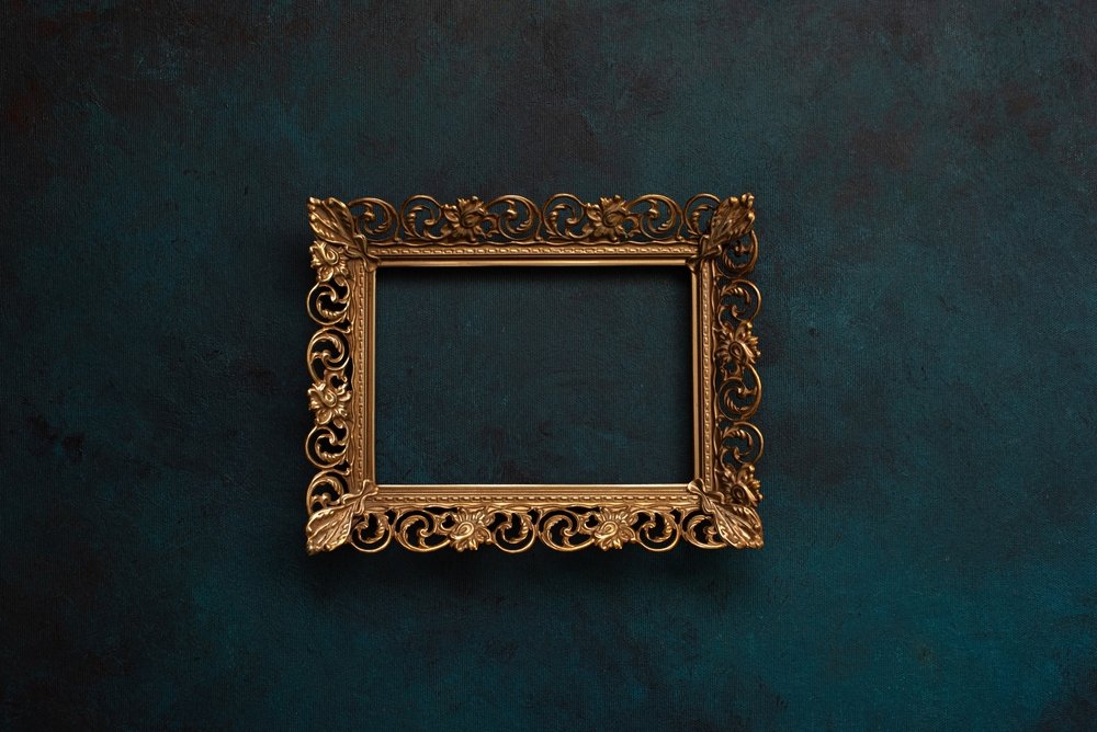 Vintage,Openwork,Bronze,Metal,Frame,On,A,Blue,Wall,Background,